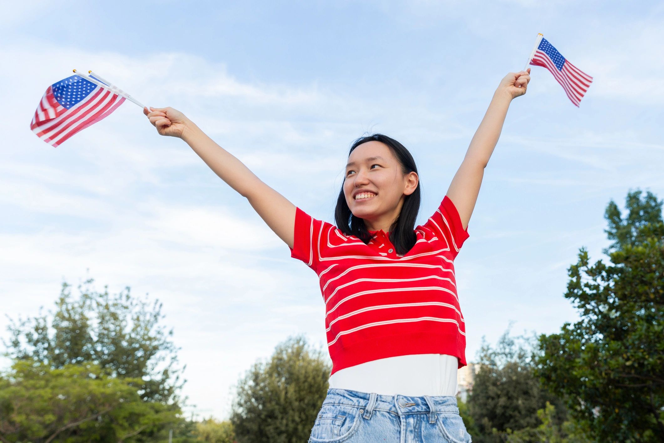 Woman holding American flags outdoors